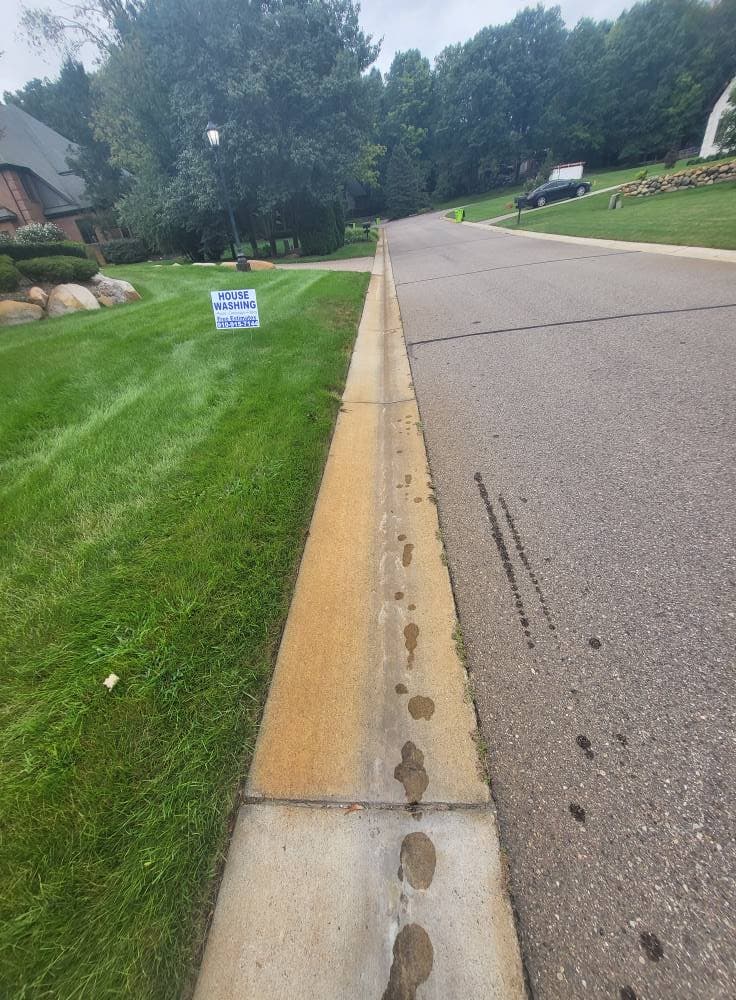 Neighborhood curbline and gutter edge with staining before HOA-focused cleaning