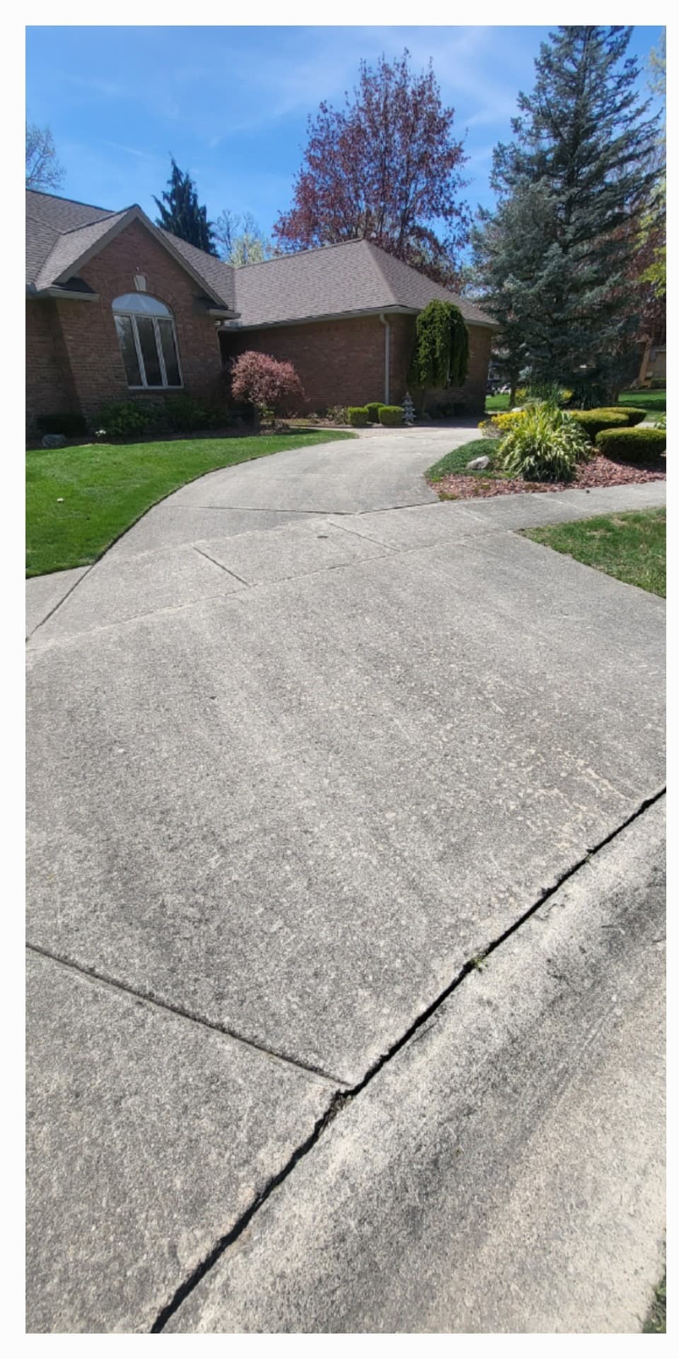 Wide residential driveway approach with uniform weathering before cleaning