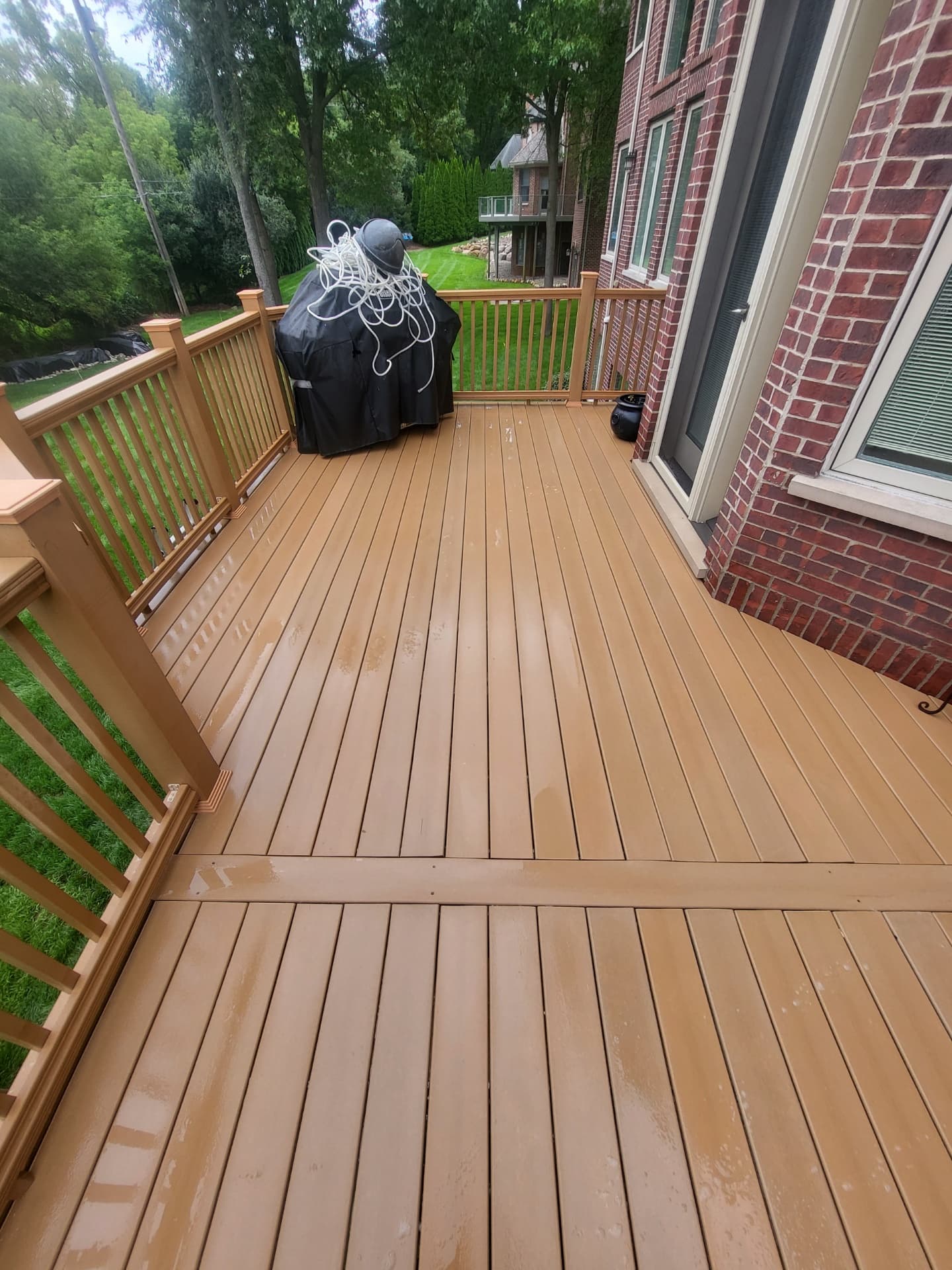 Composite deck run along railing brightened and clean after washing