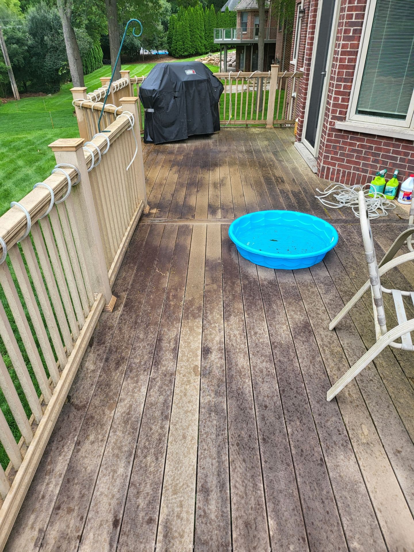 Composite deck run along railing with embedded grime before cleaning