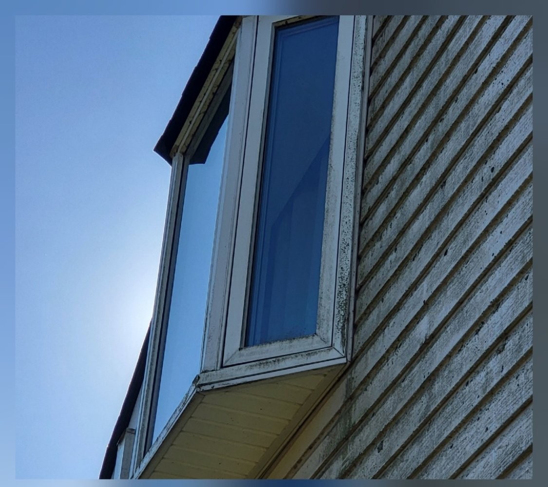 Close-up of window trim and siding with dirt before washing